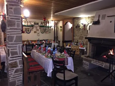 a dining room with tables and chairs and a fireplace at Nevada Aparthotel in Pamporovo