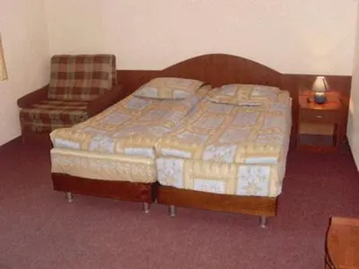 a hotel room with a bed and a chair and a chair at Mavrikova Kushta in Bansko