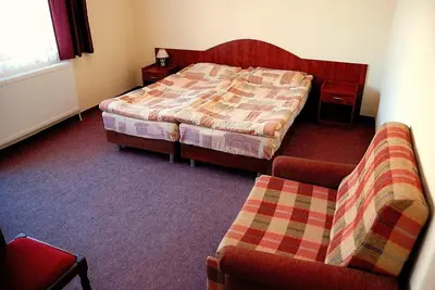 a bedroom with a bed and a couch and a chair at Mavrikova Kushta in Bansko