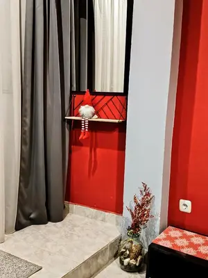 a red door with a bird in a bird feeder at Apartment Diana in Resilovo