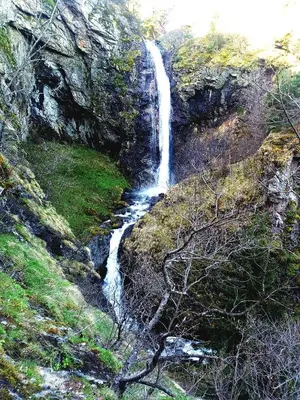 a waterfall on the side of a hill with grass at Apartment Diana in Resilovo