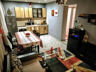 a living room with a table and a kitchen at Apartment Diana in Resilovo
