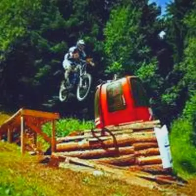 a person on a dirt bike jumping over a pile of logs at Apartment in Borovets Gardens C17 in Borovets