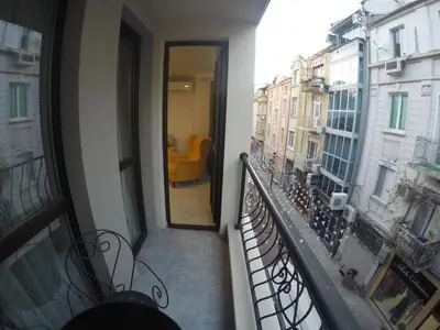 a balcony of a building with a yellow chair at Vacation Apartment in Plovdiv