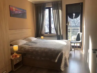 a bedroom with a bed and a chair and a window at Apartment 46 in Sofia