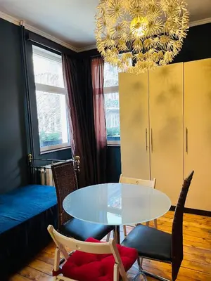 a dining room with a table and chairs and a chandelier at Lovely place in Sofia