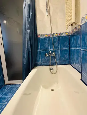 a bath tub in a bathroom with blue tiles at Lovely place in Sofia