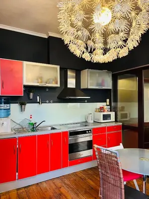 a kitchen with red cabinets and a large chandelier at Lovely place in Sofia