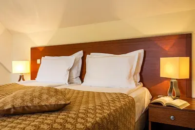 a hotel room with two beds and two lamps at Sofia Place Hotel by HMG in Sofia
