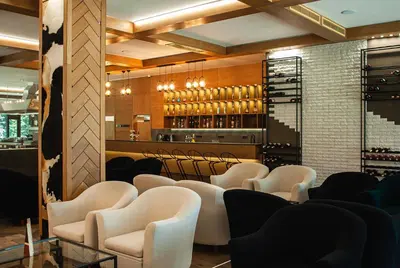 a restaurant with white chairs and a bar at Park Hotel Ela in Borovets