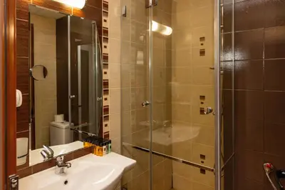 a bathroom with a sink and a glass shower at Park Hotel Ela in Borovets