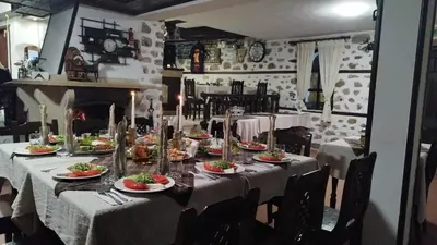 a dining room with a table with plates of food at Hotel Bolyarka in Melnik