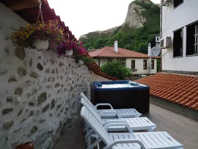 a group of chairs and a trash can on a wall at Hotel Bolyarka in Melnik