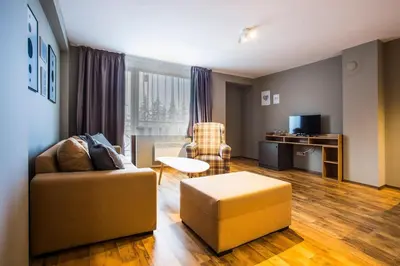 a living room with a couch and a chair at Sunny Hills Ski&Wellness in Pamporovo
