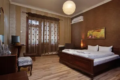 a bedroom with a bed and a desk and a television at Anita House in Perushtitsa