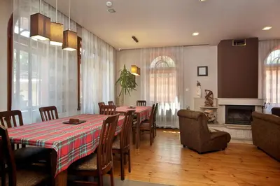 a dining room with tables and chairs and a fireplace at Anita House in Perushtitsa