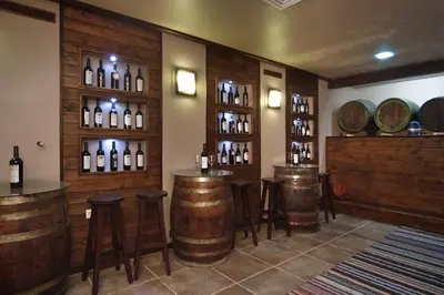 a wine tasting room with wine barrels and stools at Anita House in Perushtitsa