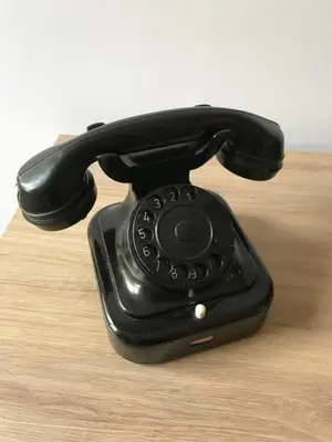 a black phone sitting on top of a wooden table at Downtown Wanderlust Apartment in Sofia