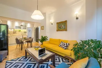 a living room with a yellow couch and a table at Downtown Wanderlust Apartment in Sofia