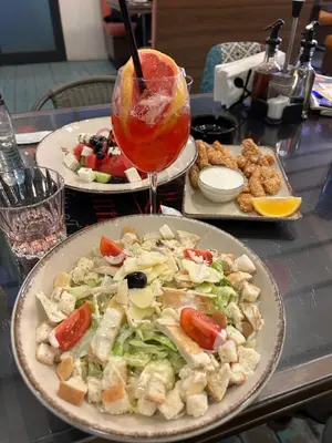a table with two plates of food and a drink at Hotel Elit in Devin