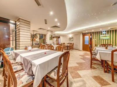 a restaurant with tables and chairs in a room at Hotel Elit in Devin