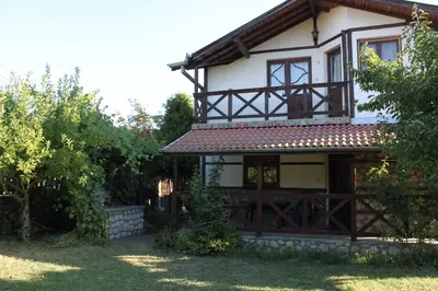 a house with a balcony on top of it at Belcheva kashta in Banya