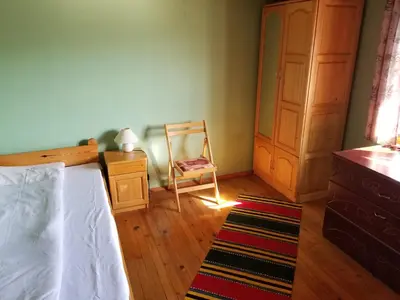 a bedroom with a bed and a chair and a dresser at Belcheva kashta in Banya