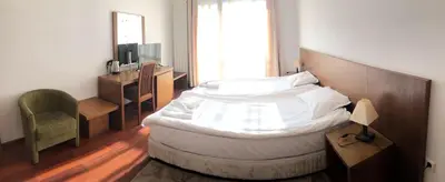 a bedroom with a large bed and a chair at Bellevue Residence Apartments in Bansko