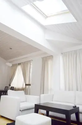 a white living room with white couches and a table at Bellevue Residence Apartments in Bansko
