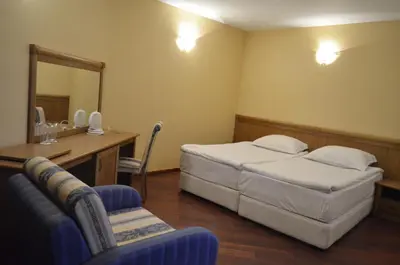 a bedroom with a bed and a vanity and a mirror at Bellevue Residence Apartments in Bansko