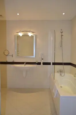 a bathroom with a tub and a sink and a mirror at Bellevue Residence Apartments in Bansko