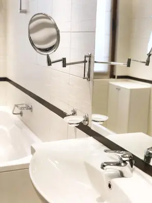 a bathroom with a sink and a mirror and a tub at Bellevue Residence Apartments in Bansko