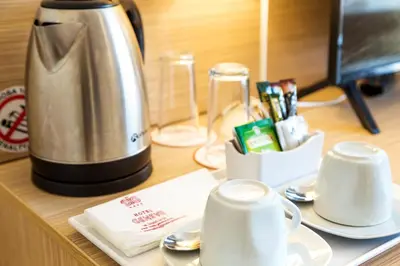 a counter with a coffee pot and cups on it at Geneva Hotel in Sofia