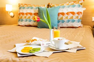 a tray of food and coffee on a bed at Geneva Hotel in Sofia