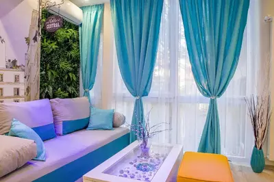 a living room with a couch and blue curtains at City center Apartment in Sofia
