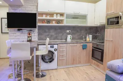 a kitchen with a washing machine and a tv at City center Apartment in Sofia