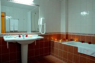 a bathroom with two sinks and a mirror and a tub at Hotel Prespa in Pamporovo