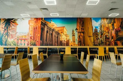 a table and chairs in a restaurant with a mural at Hotel Ihtiman in Ikhtiman