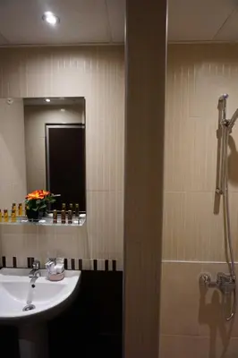 a bathroom with a sink and a mirror and a shower at Hotel Ihtiman in Ikhtiman
