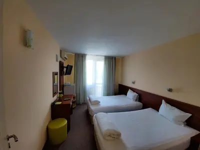 a hotel room with two beds and a window at Hotel Galant in Sofia
