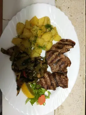 a white plate of food with meat and potatoes at Hotel Galant in Sofia