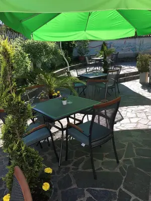 a group of tables and chairs with green umbrellas at Hotel Galant in Sofia
