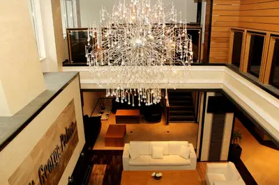 a living room with a chandelier and a couch at Saint George Palace Aparthotel in Bansko