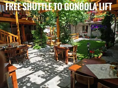 a patio with tables and chairs in a yard at Mamin Kolio in Bansko