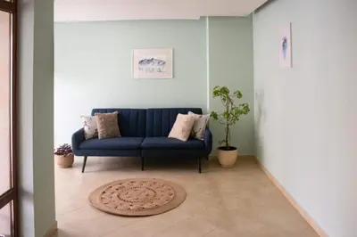 a blue couch in a living room with a rug at Meteor Family Hotel in Chepelare