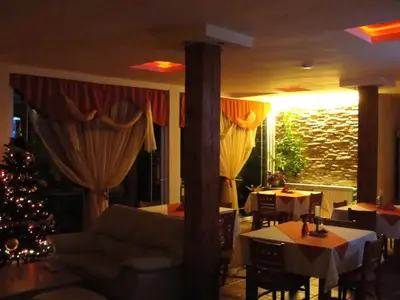 a dining room with a christmas tree and tables at Zasheva Kushta Guesthouse in Bansko