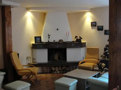 a living room with a fireplace and a christmas tree at Zasheva Kushta Guesthouse in Bansko