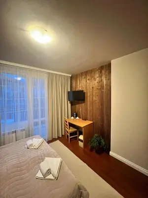 a bedroom with a bed and a desk and a television at Zasheva Kushta Guesthouse in Bansko
