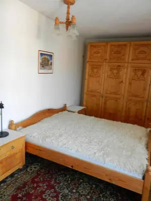 a bedroom with a wooden bed and wooden cabinets at Damianka Guest House in Bansko