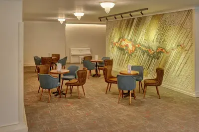 a waiting room with tables and chairs and a mural at Augusta SPA Hotel in Hisarya